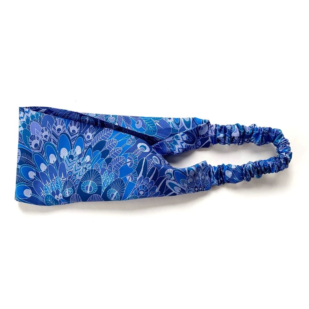 A blue patterned Liberty London Tana Lawn cotton headband with a gathered elastic band, displayed flat on a white background.