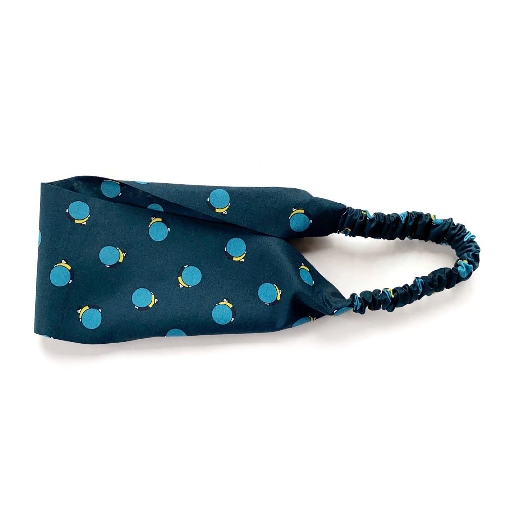 A dark navy blue Liberty London Tana Lawn cotton headband, featuring an elastic back, shown on a plain white background.