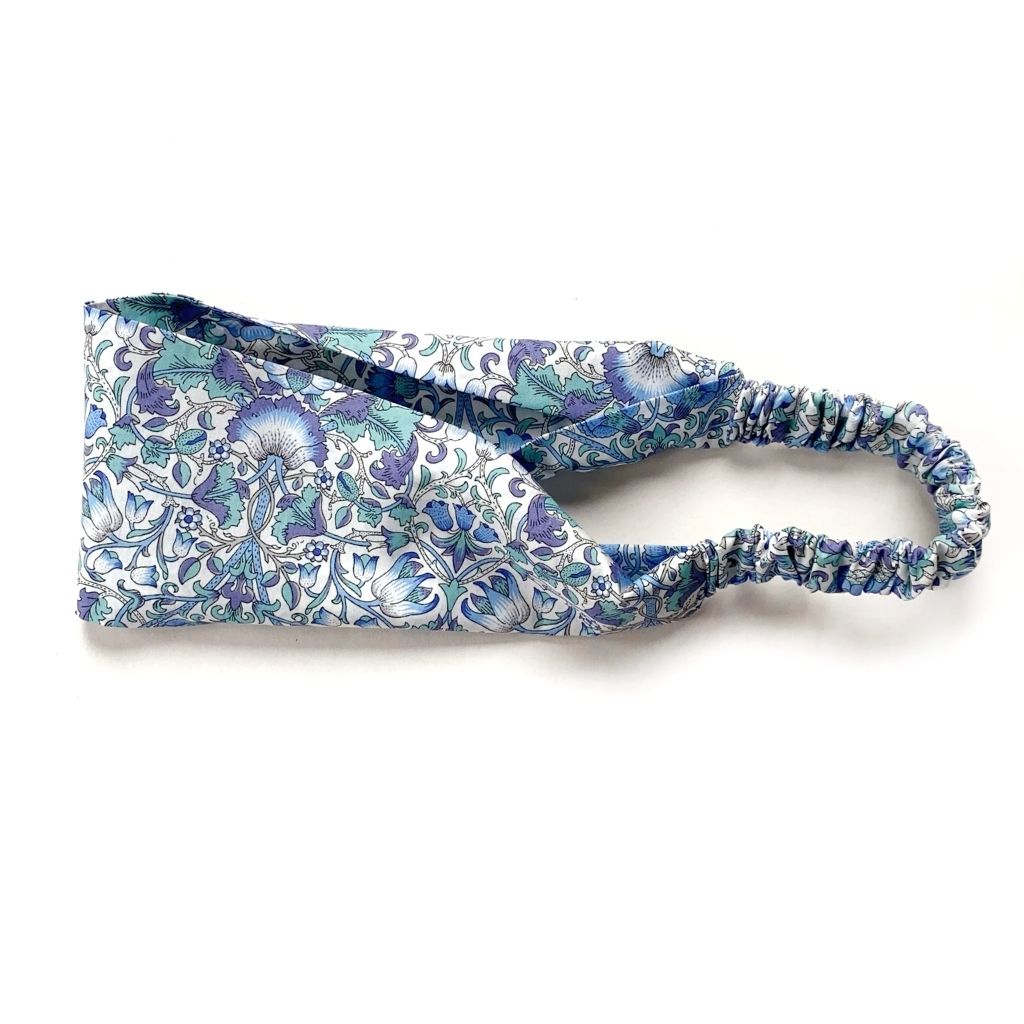 Liberty London Tana Lawn cotton headband with william morris print" lodden" a blue and white floral pattern, featuring an elastic back, laid flat on a white background.