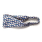 Liberty London Tana Lawn cotton headband with a blue, white, and gray floral pattern, featuring a gathered elastic back, shown on a plain white background.