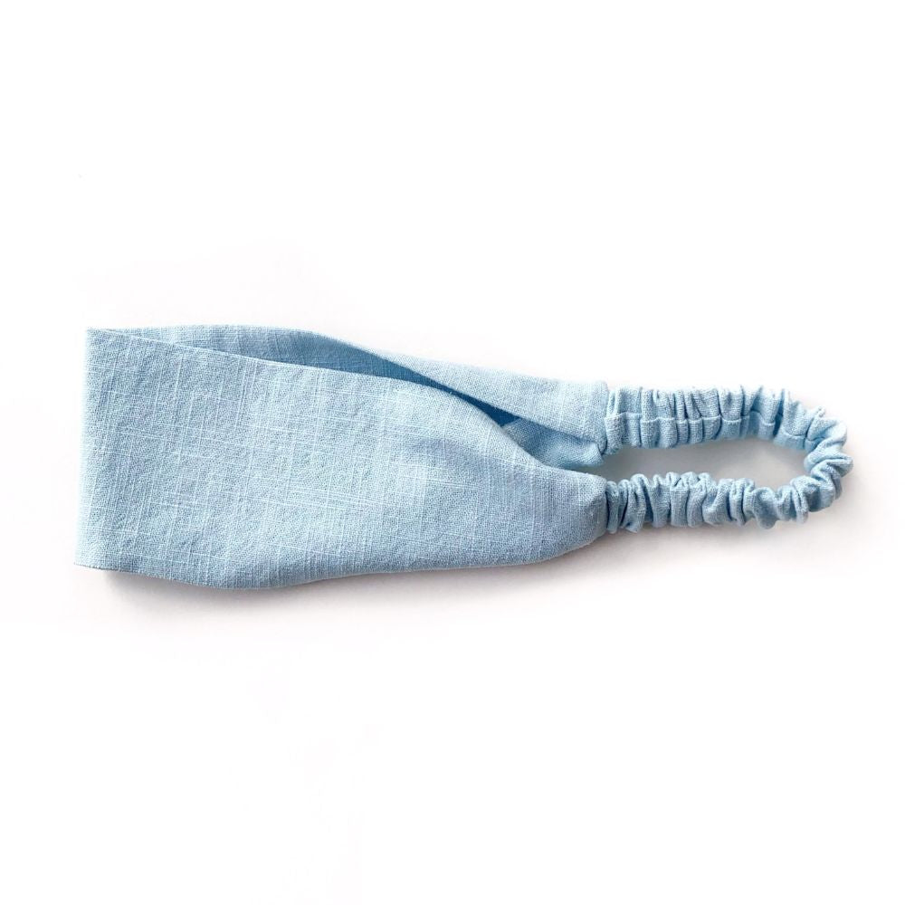 Light blue linen headband with elastic on the back on a white background
