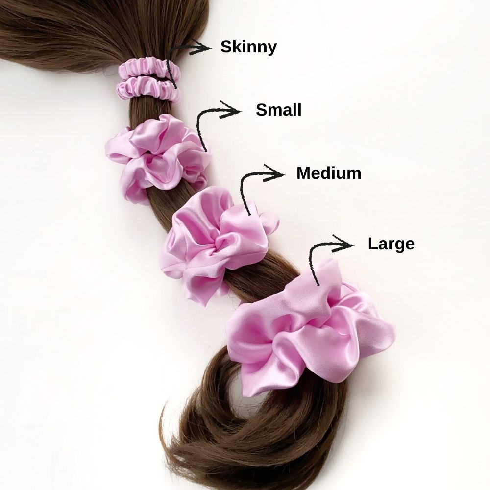 Set of lilac pure mulberry silk satin scrunchies and hair ties of different sizes on a ponytail with labeled sizes.