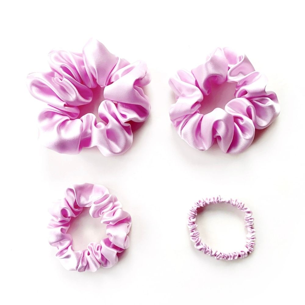 Set of lilac pure mulberry silk satin scrunchies and hair ties on a white background