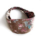 A brown cotton linen headband with a rose floral pattern in pink, blue shown on a plain white background.