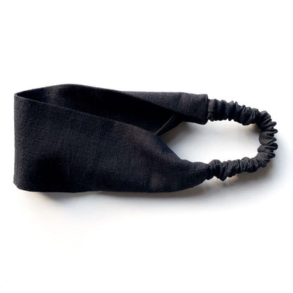 A black flat linen headband with an elastic back, displayed on a clean white background.