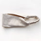 A light beige linen headband with a gathered elastic back, photographed on a clean white background.