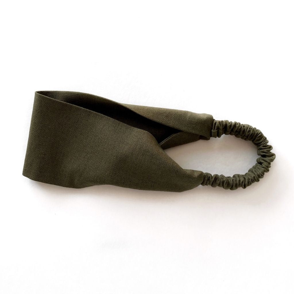 An olive green flat linen headband with an elastic back, displayed on a clean white background.