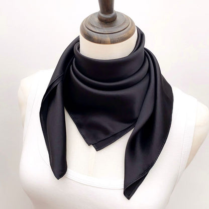 mannequin wears a black mulberry silk square scarf around her neck