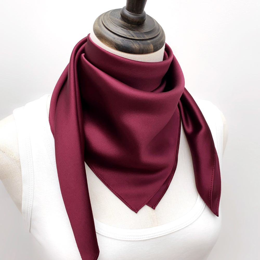 mannequin wears a burgundy mulberry silk square scarf around her neck