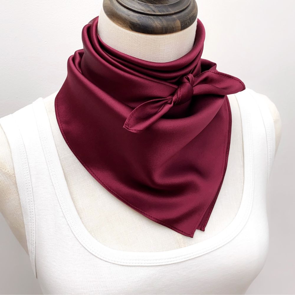 mannequin wears a burgundy mulberry silk square scarf around her neck