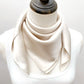 mannequin wears a solid light beige mulberry silk square bandana scarf around her neck