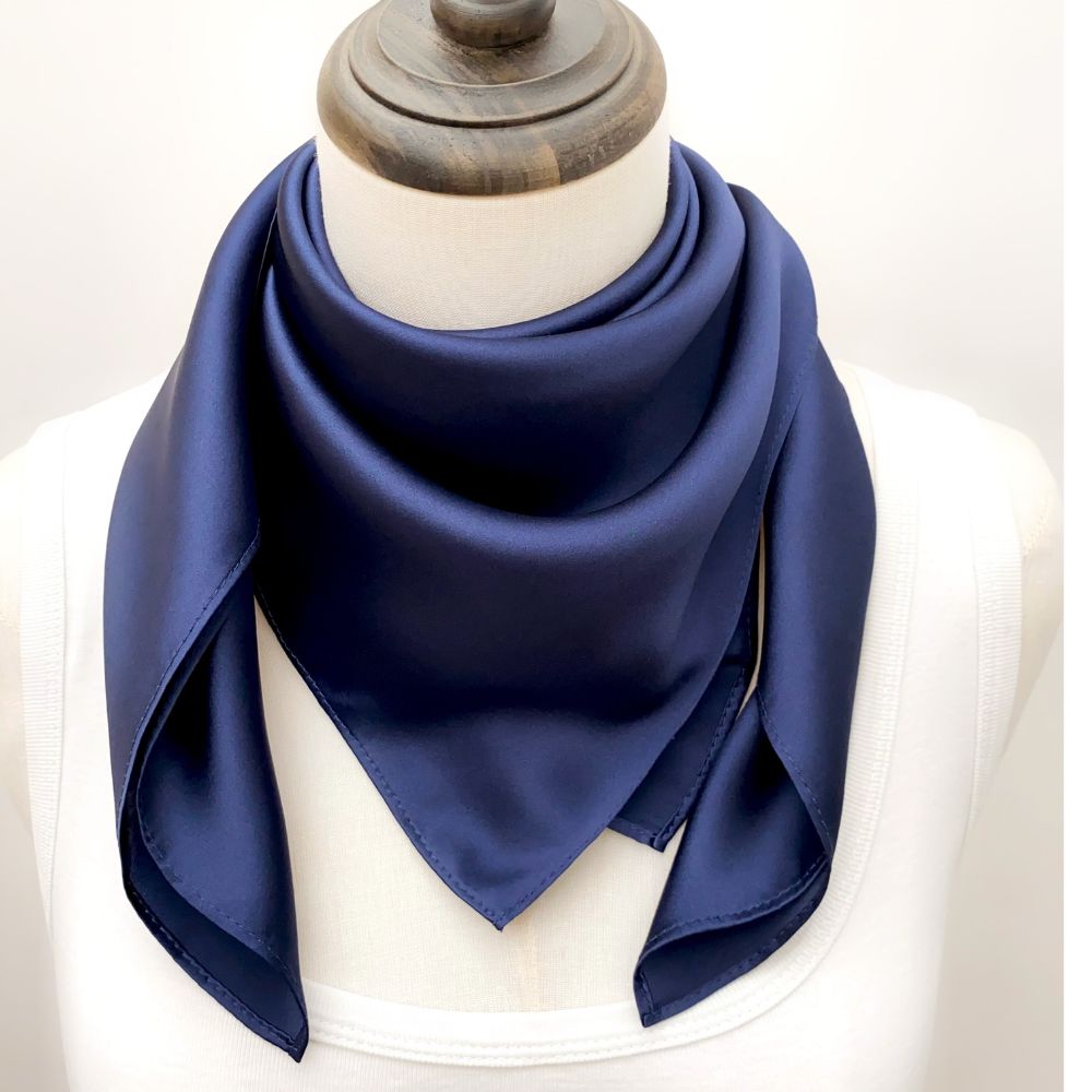mannequin wears a solid navy blue mulberry silk square scarf around her neck