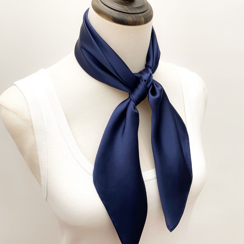 mannequin wears a solid navy blue mulberry silk square bandana scarf around her neck