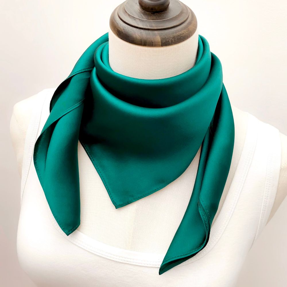 mannequin wears a solid emerald green mulberry silk square bandana scarf around her neck