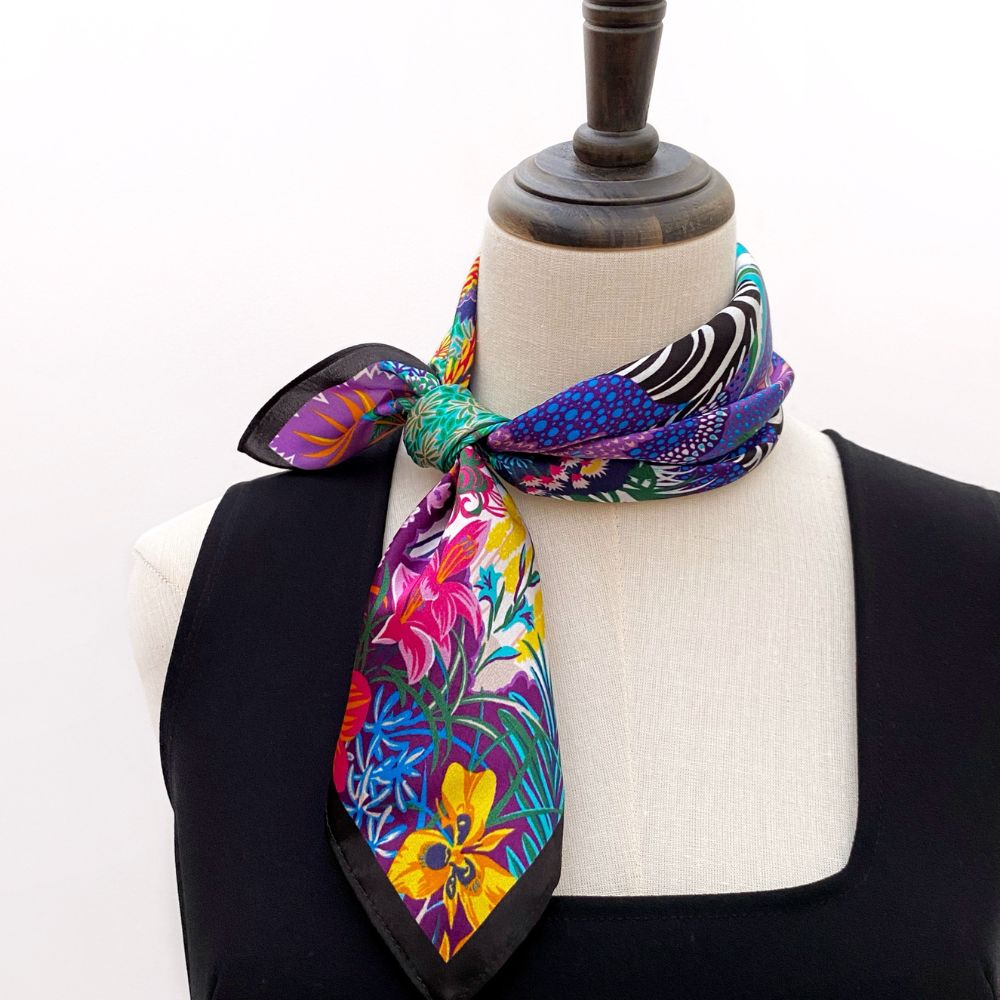 Colourful purple floral mulberry silk square neck scarf on a mannequin with a white background
