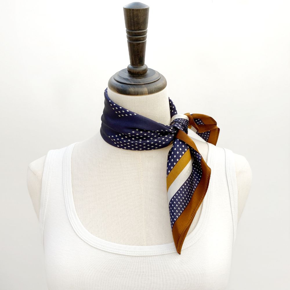 Navy blue and brown geometric mulberry silk neckerchief scarf on a mannequin with a white background