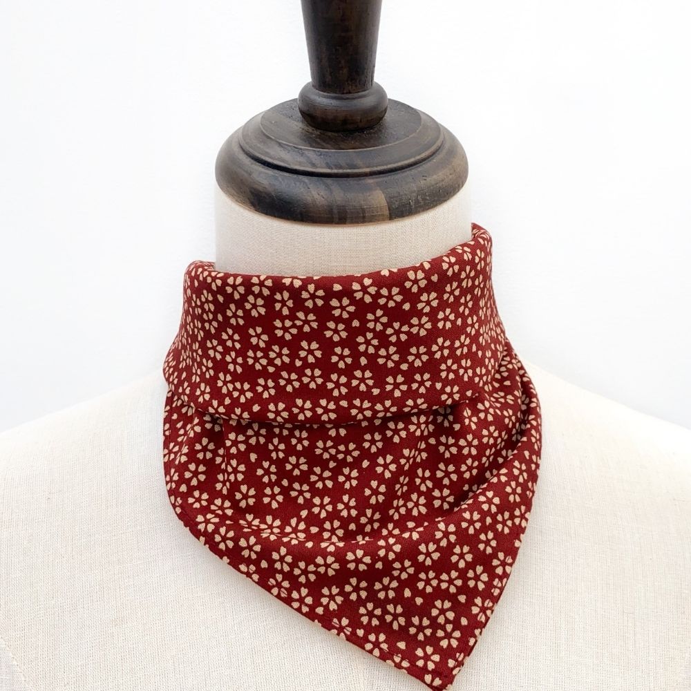 Red cherry blossom sakura floral patterned Japanese cotton bandana square neck scarf on a mannequin neck with a white background