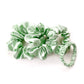 Set of mint green mulberry silk scrunchies and hair ties on a white surface