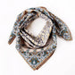 Yellow and teal botanical paisley mulberrry silk and cotton blend scarf styled in a loose loop on a white background.