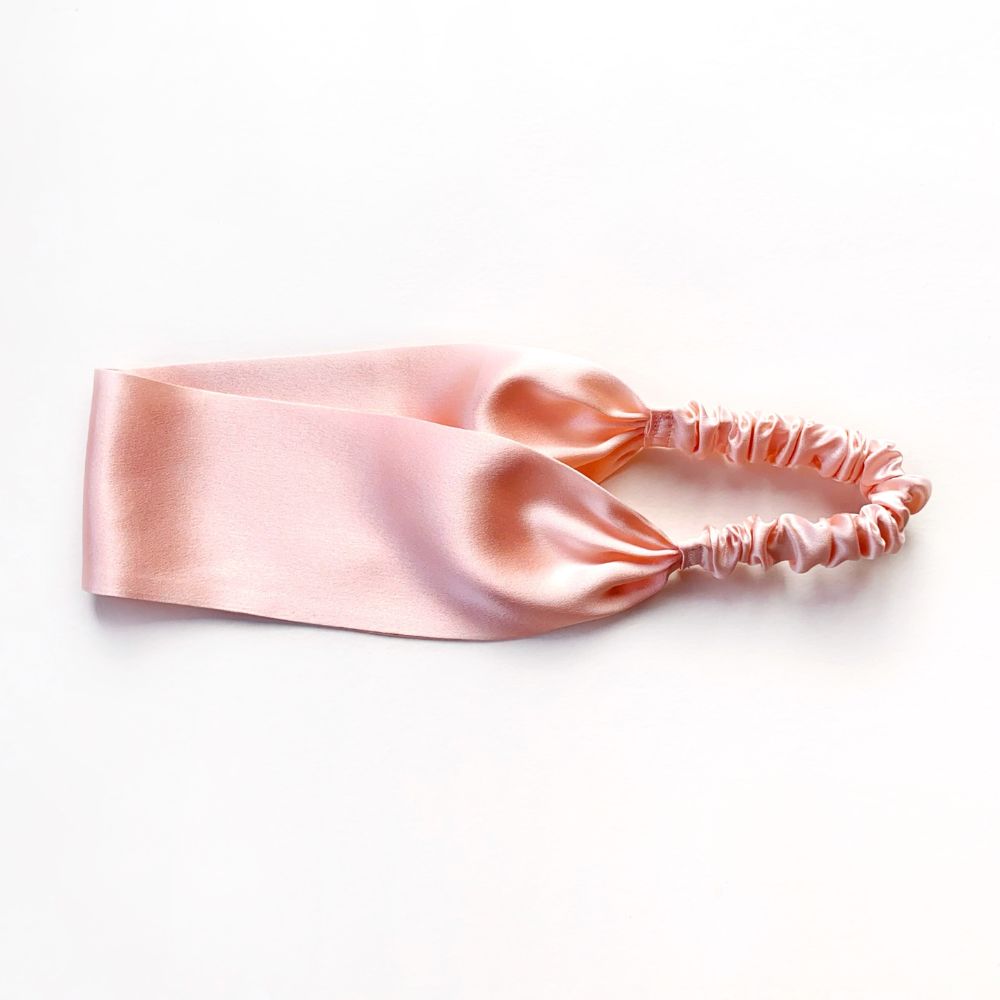 Pink silk satin headband on a white background