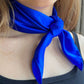 Royal blue silk satin neckerchief tied closely around a woman’s neck