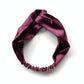 A knotted mulberry silk satin headband in a deep maroon color, displayed on a clean white background.