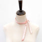 Mannequin wearing a pink silk ribbon on a white background