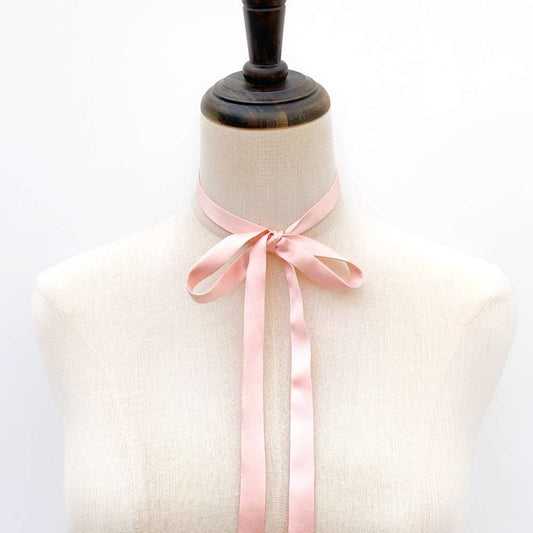 Mannequin wearing a light pink mulberry silk satin ribbon scarf against a white background
