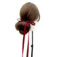 Mannequin head with brown hair styled in a bun with a red mulberry silk skinny hair tie on a white background