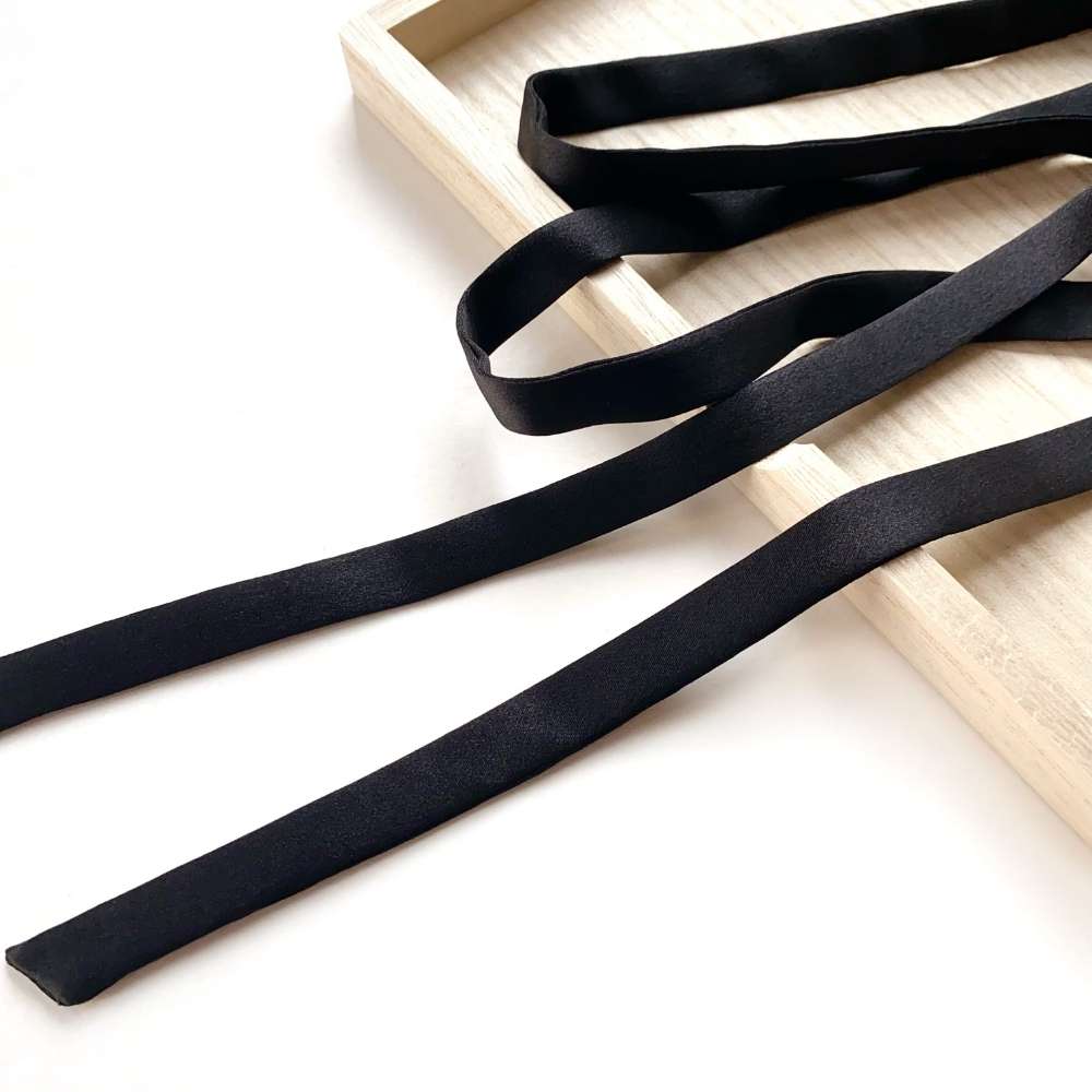 Black mulberry silk ribbon on a light wooden surface