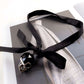 Transform your look. Style the ultra-skinny black silk ribbon as a statement charm choker for an effortless touch of Parisian-chic luxury.