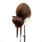 Mannequin head with brown hair styled in a bun with a chocolate brown mulberry silk satin ribbon hair tie on a white background