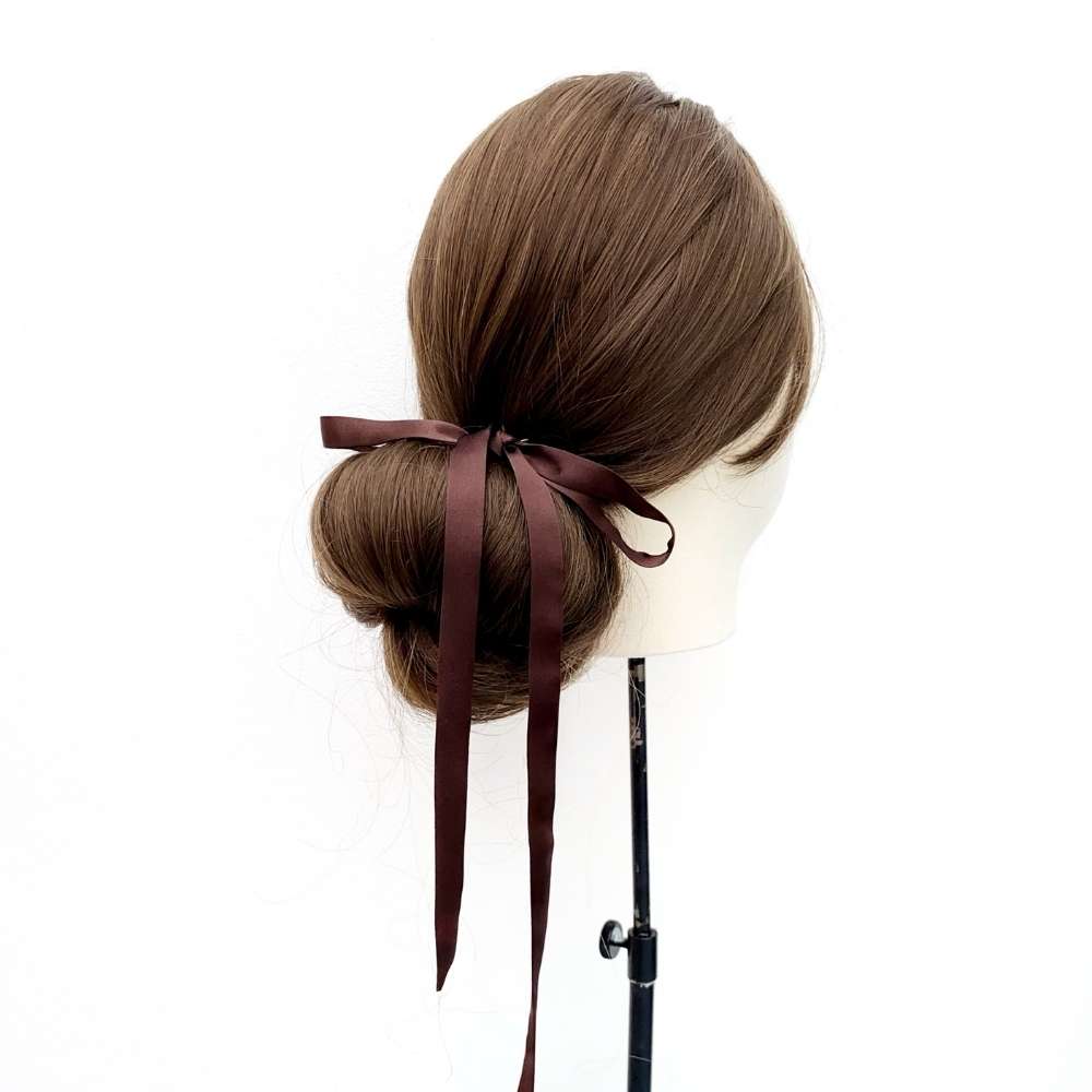 Mannequin head with brown hair styled in a bun with a chocolate brown mulberry silk satin ribbon hair tie on a white background