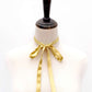 Mannequin with a Gold mulberry silk skinny ribbon scarf  tied around its neck on a white background