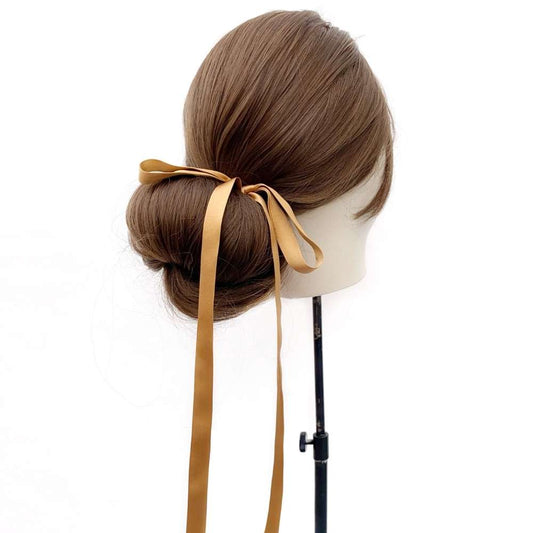 Mannequin head with brown hair styled in a bun with a Copper brown ultra skinny mulberry silk ribbon hair tie on a white background