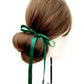 Hair bun with a forest green mulberry silk satin ribbon hair scarf on a white background