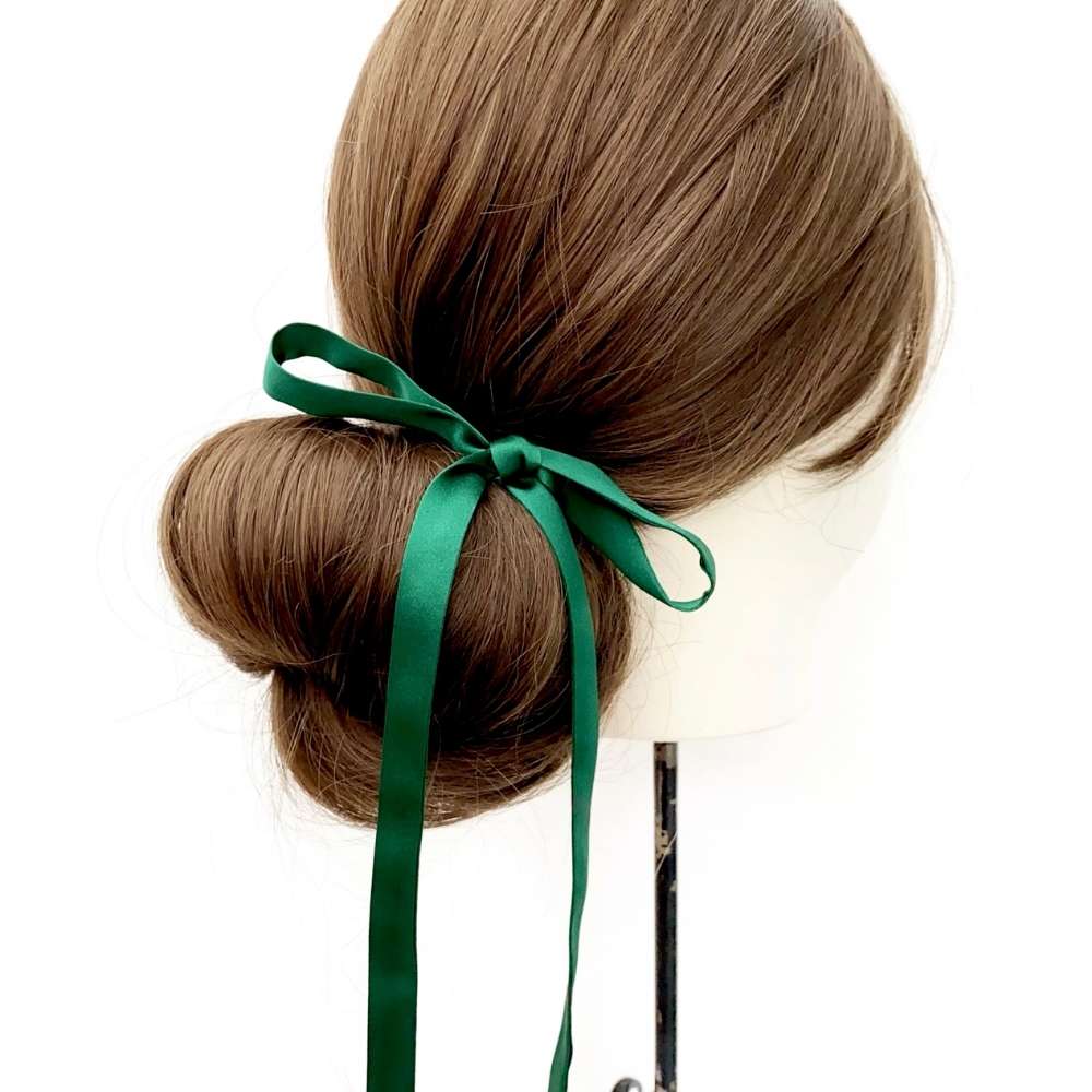 Hair bun with a forest green mulberry silk satin ribbon hair scarf on a white background