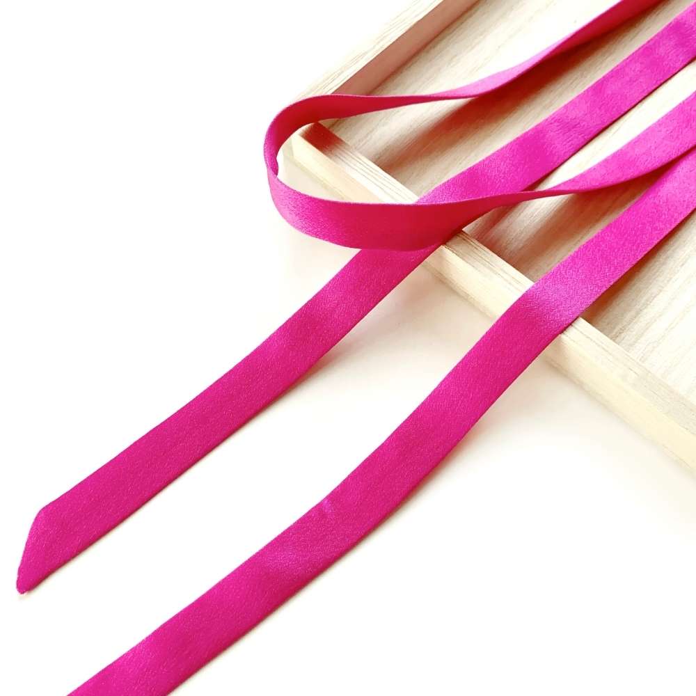 hot pink mulberry silk satin ribbon scarf on a light wooden surface