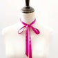 Mannequin wearing a bright pink mulberry silk ribbon necktie scarf on a white background
