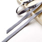 Gray mulberry silk satin ribbon scarf on a wooden block with a white background