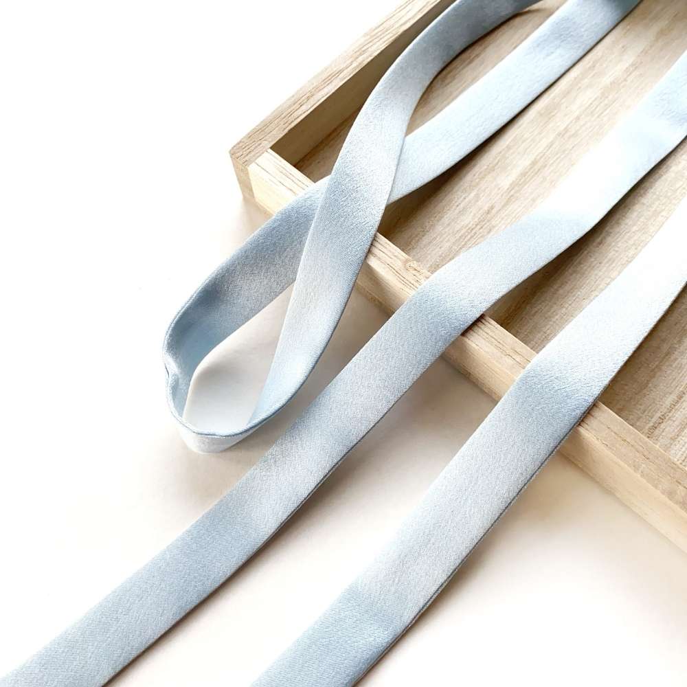 Light blue mulberry silk satin ribbon on a wooden surface