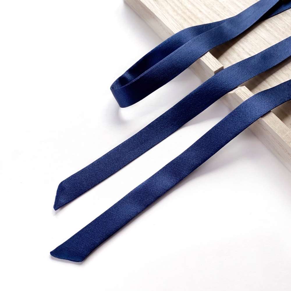 sapphire blue mulberry silk satin ribbon scarf on a light wooden surface