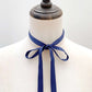 Mannequin wearing a sapphire blue silk ribbon neck scarf against a plain background