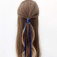 Long brown hair with a sapphire blue mulberry silk hair tie tied in a ponytail on a white background