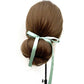 Mannequin head with brown hair styled in a bun and Seafoam green mulberry silk satin ribbon scarf on a white background