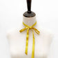 Mannequin with a Golden Yellow mulberry silk satin ribbon  scarf tied around its neck on a white background