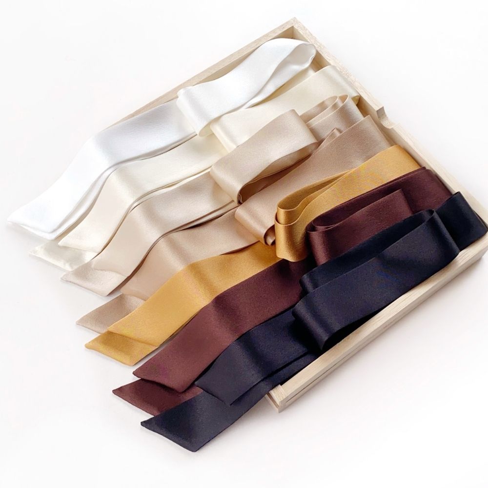 A set of mulberry silk satin skinny scarves in multiple colors, including white, ivory cream, beige, gold, brown, and black