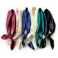 six plain mulberry silk square scarves in burgundy, light beige, navy blue, ivory, emerald green and black tied into the neckerchiefs on the white background