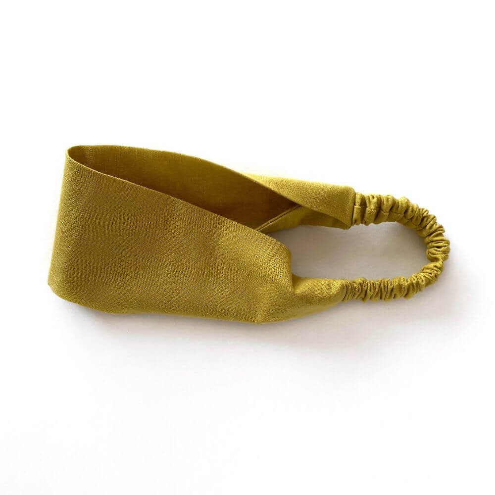 Mustard yellow linen headband on a white background