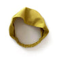 Mustard yellow linen headband on a white background